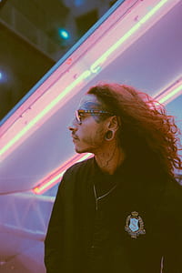 man wearing eyeglasses wearing jacket with dollar sign patch thumbnail