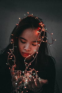 Woman Wears Black Long-sleeved Shirt Hold String Lights thumbnail