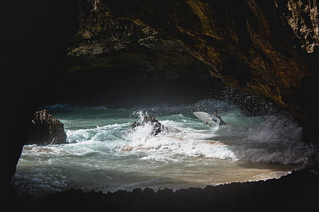 person holding white surfboard in sea during daytime thumbnail
