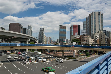 vehicles traveling near buildings during daytime thumbnail