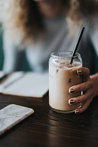 woman holding clear drinking glass thumbnail
