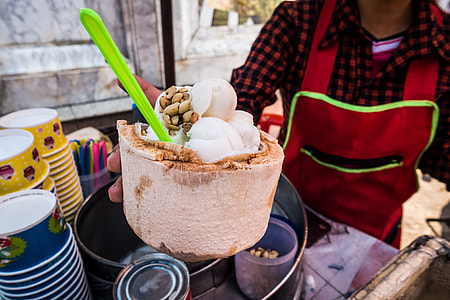 Serving fresh coconut ice cream in young coconut thumbnail