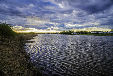 Sunset on the river under the clouds thumbnail