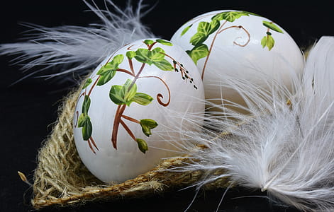 two white-and-green easter eggs on brown wicker basket thumbnail