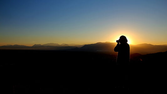 silhouette photo of person holding camera thumbnail