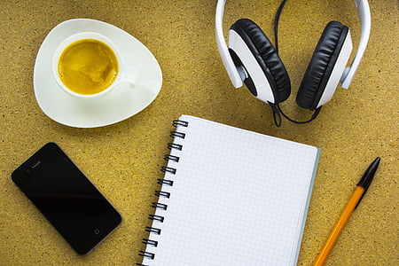 flat-lay photography of notebook, smartphone, pen, cup of coffee, and wired headphones thumbnail