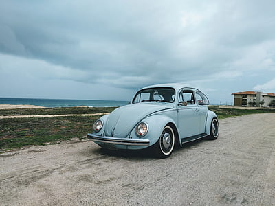 teal Volkswagen Beetle on road during daytime thumbnail