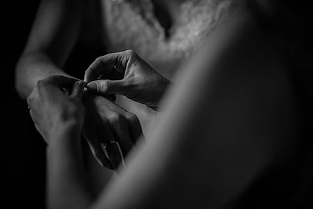 grayscale photo of person putting bracelet on person thumbnail