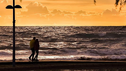 photography of couple looking at sea waves thumbnail