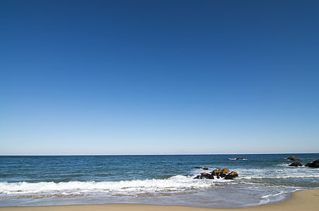 waves of body of water on beige sand thumbnail