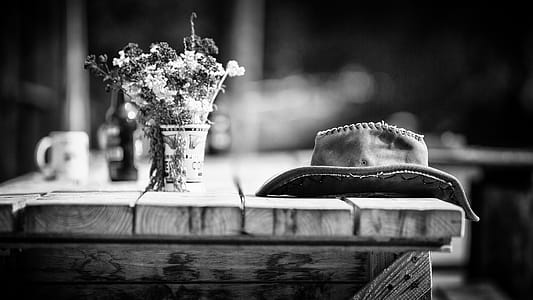 Grayscale Photography of Hat on Wooden Table thumbnail