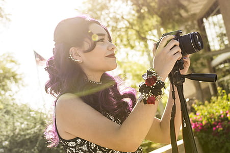 woman holding black DSLR camera during daytime thumbnail