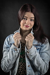 woman in black and white leopard print scoop-neck top and blue denim jacket taking photo thumbnail