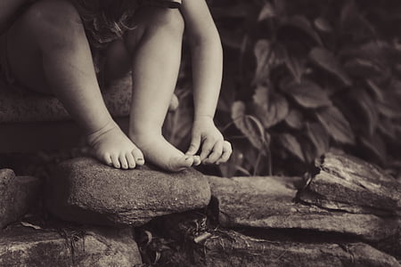 toddler sitting on brown rock thumbnail
