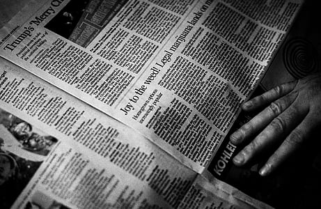 grayscale photo of person holding newspaper thumbnail
