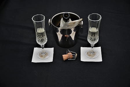 two white flute glasses and opened bottle in ice bucket thumbnail
