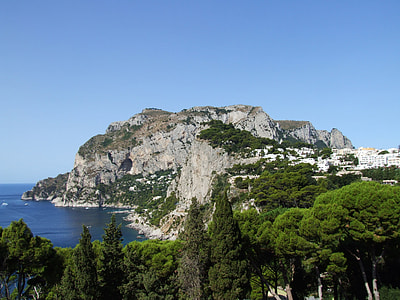 gray cliff near body of water under blue sky during daytime thumbnail