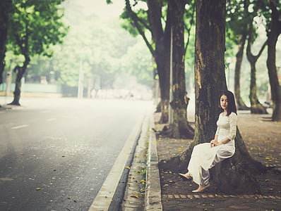woman in white dress sitting beside tree thumbnail