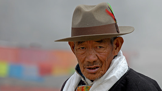 man wearing brown fedora hat and grey scarf thumbnail