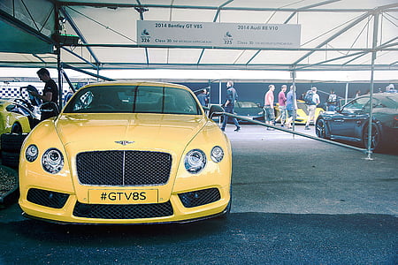 yellow car parked under white tent thumbnail