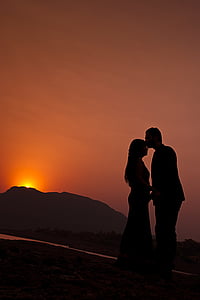 silhouette of man kissing forehead of woman during sunset thumbnail