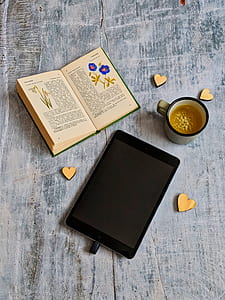 black iPad near book and cup of coffee thumbnail