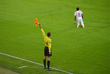 soccer referee raising yellow flag thumbnail