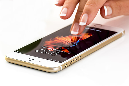 Woman’s hand using iPhone mobile smartphone thumbnail