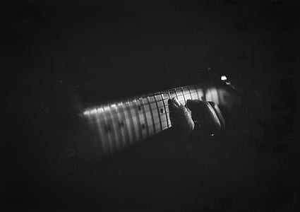 grayscale photography of person playing guitar thumbnail