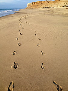 photo of footprints on seashore under clear blue sky during daytime thumbnail