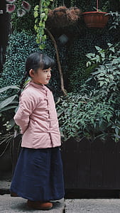 girl standing near green leafed plants thumbnail