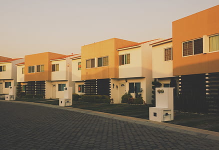 photo of white-and-orange concrete houses under cloudy sky thumbnail