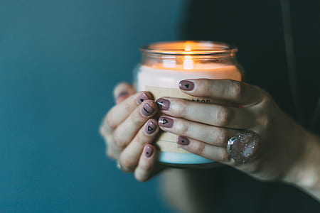 woman holding clear glass scented votive candle thumbnail