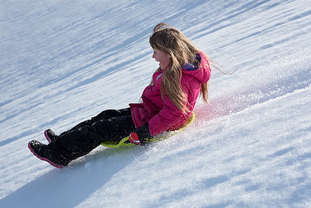 woman in pink bubble hoodie riding green sled thumbnail