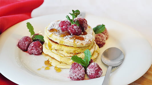 pancakes served on white ceramic plate with raspberries thumbnail
