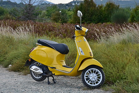 yellow motor scooter parked near grass thumbnail