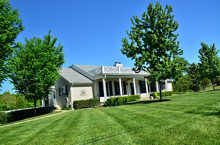 white house surrounded with green lawn and green trees at daytime thumbnail