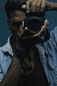 Man Holding Black Dslr Camera thumbnail
