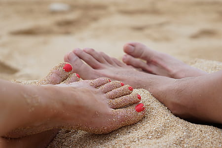 two pairs of human foot on sand thumbnail