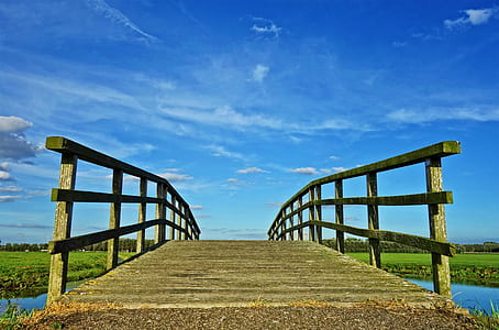 low angle photo of brown wooden bridge taken at daytime thumbnail