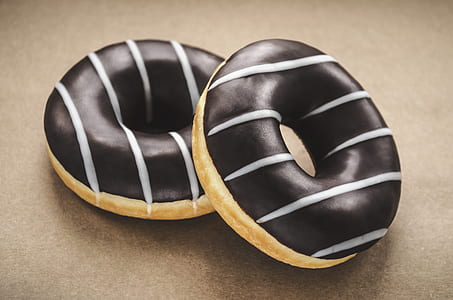 two chocolate doughnuts on brown surface thumbnail
