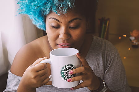 woman holding Starbucks mug near window thumbnail