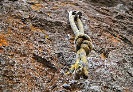 yellow and black rope hanged on gray rock thumbnail