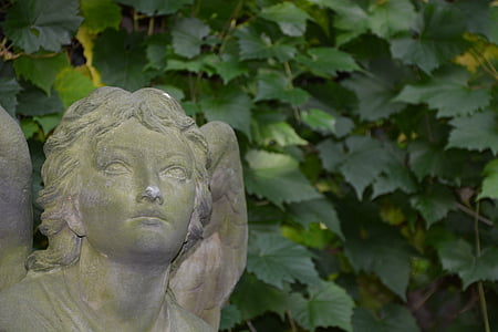 white concrete angel statue near plant thumbnail