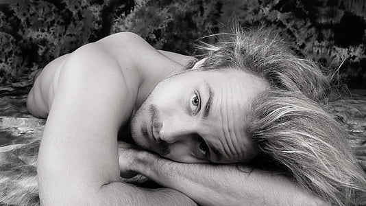 man lying on gray textile thumbnail