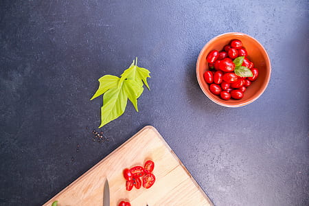 sliced tomatoes on brown wooden board near green herb thumbnail
