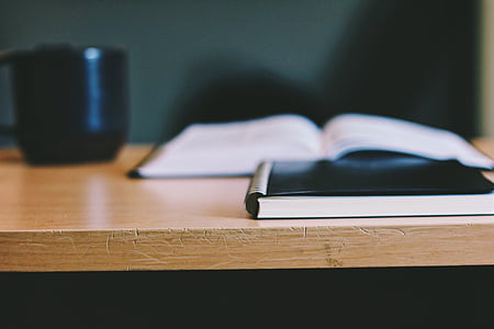 black hardbound book on brown wooden table thumbnail