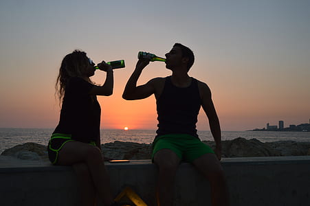 man and woman sitting on bleachers during golden hour thumbnail