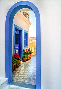 blue painted closed door with flower arrangement outside thumbnail