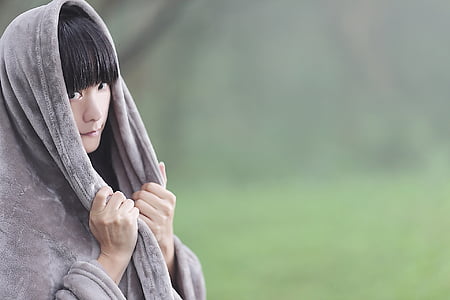 woman wearing gray hooded jacket holding it with both hands thumbnail